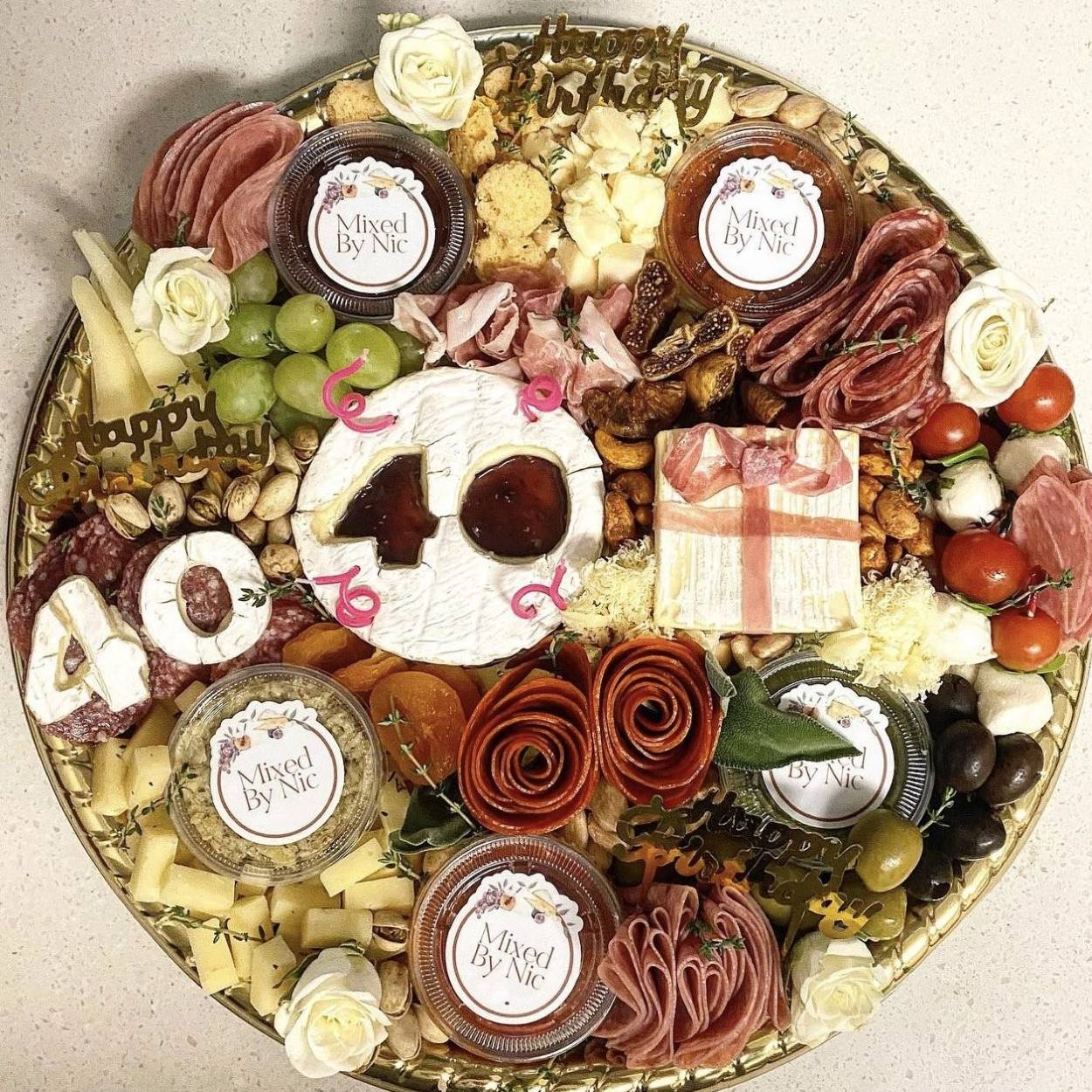 A charcuterie board featuring cheese cut into a birthday number.