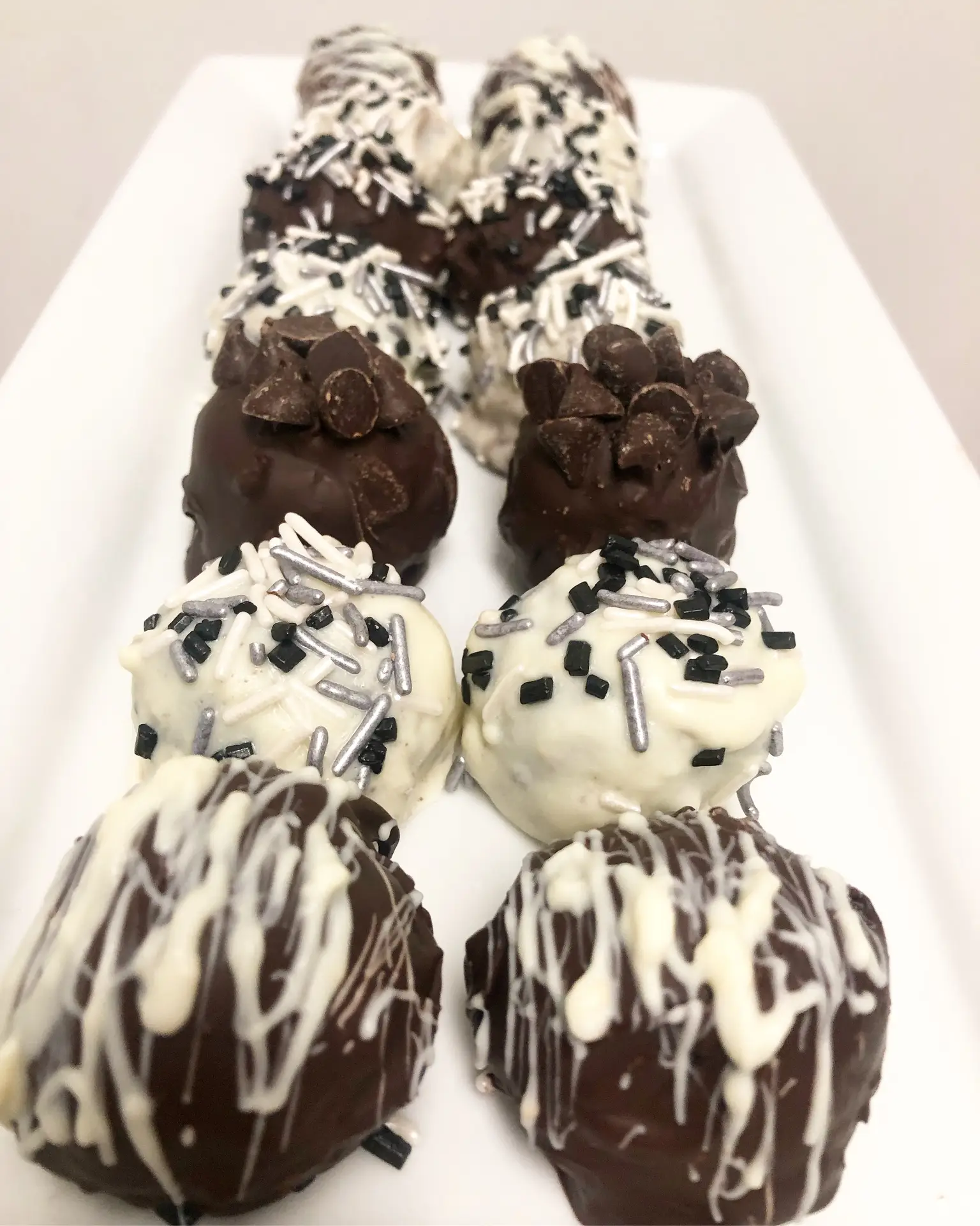Chocolate-coated Oreo truffles on a plate.